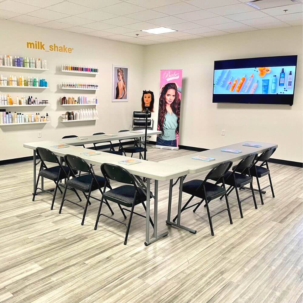 Beauty professional classroom with tables tv chairs and products on shelves