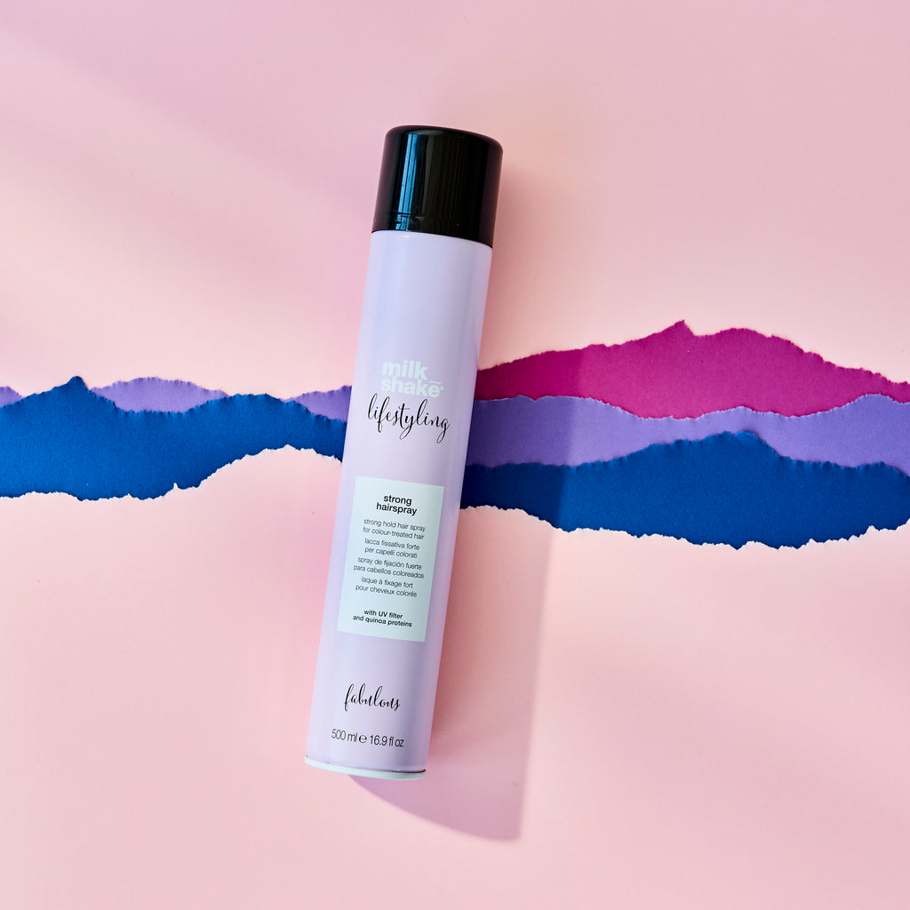 bottle of strong setting hairspray on colorful background